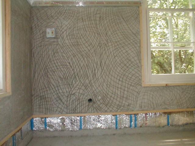 Interior wall with plaster scratch coat and window visible beyond
